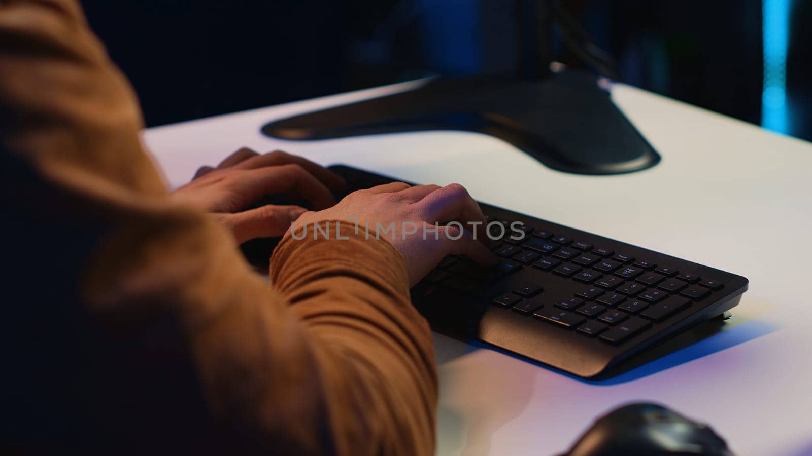 Computer scientist listening music while writing lines of code during remote job shift in home office. IT specialist enjoying audio podcast, coding on desktop PC, camera A extreme close up