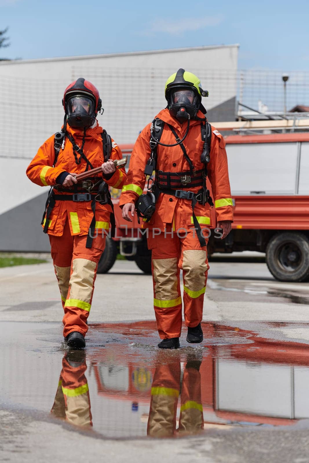 A team of confident and accomplished firefighters strides purposefully in their uniforms, exuding pride and satisfaction after successfully completing a challenging firefighting mission.