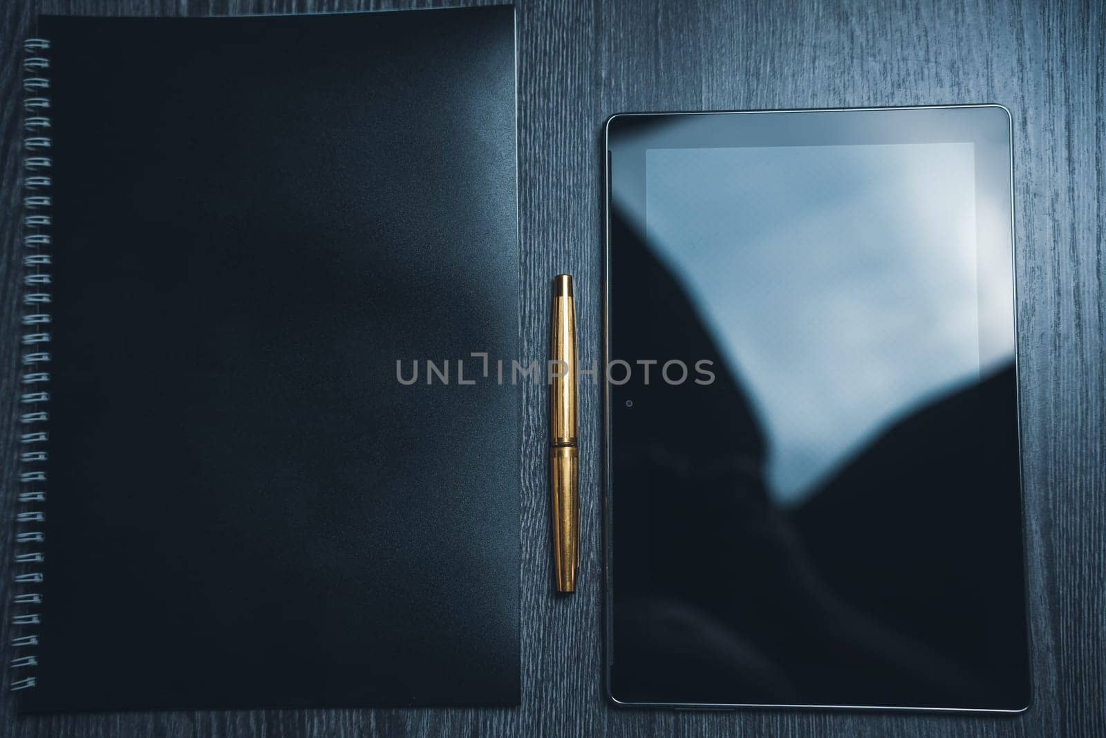 Workplace. Notebook with pen and tablet on a wooden table. Strict style. High quality photo