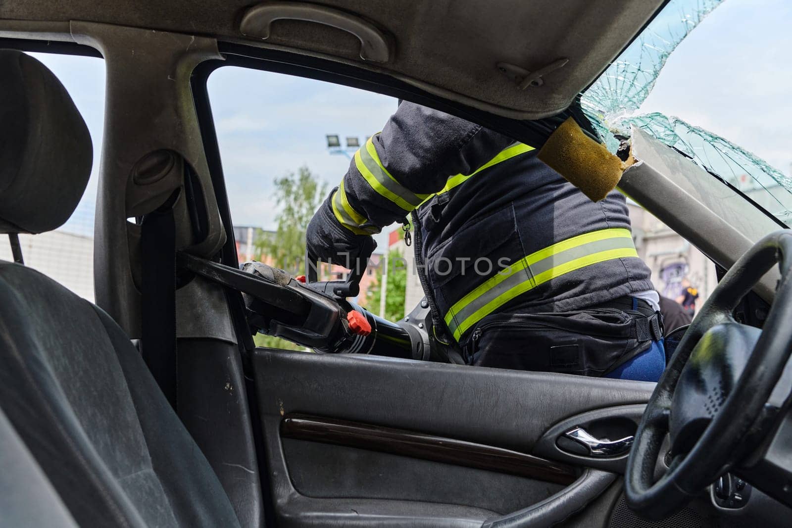 A dedicated team of professional firefighters employs specialized tools to cut and break through vehicle wreckage, showcasing their skilled collaboration and swift response in rescuing individuals involved in a car accident.