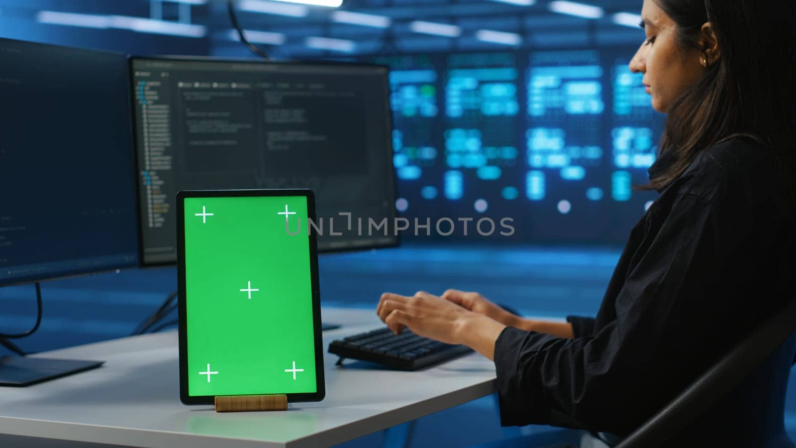 Focus on isolated screen tablet next to admin programming in server room providing computing resources for workloads. Chroma key device on desk used by worker supervising data center supercomputers