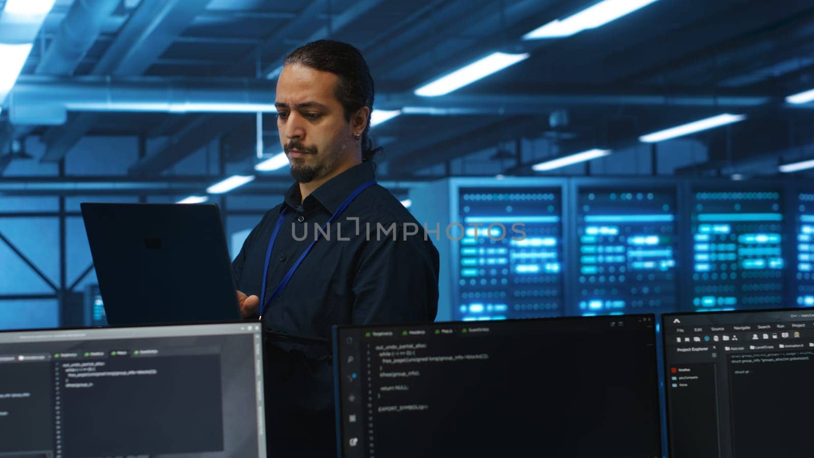 Manager overseeing server room, running code on laptop, troubleshooting and upgrading technologically advanced hardware clusters. System administrator programming in server farm