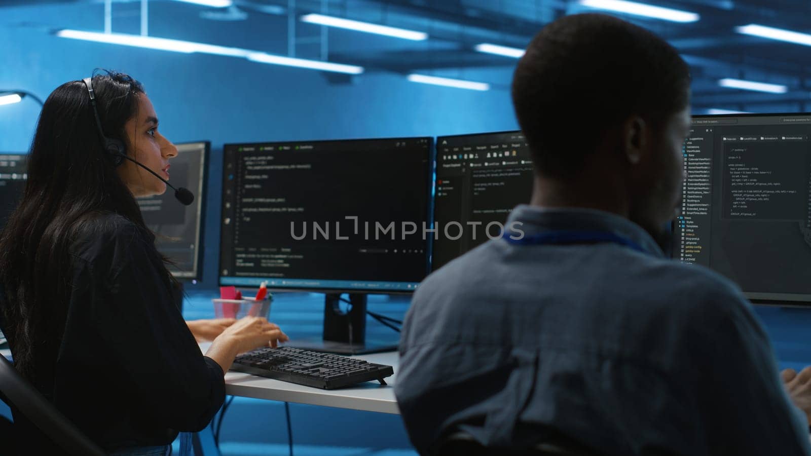 Woman talking in headphone mic, doing system analysis of server farm supercomputers. IT support worker in remote call using headset microphone in data center housing storage infrastructure