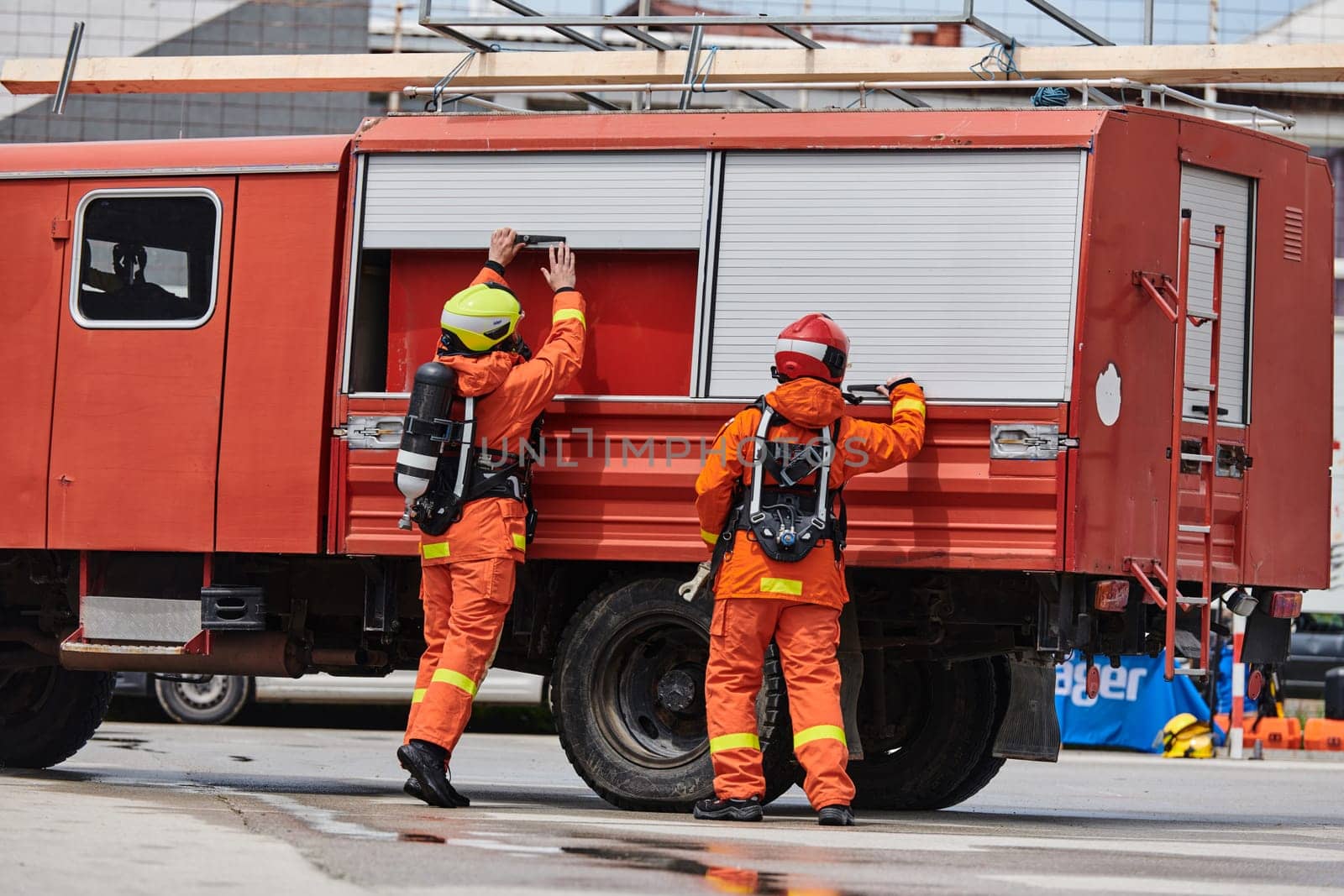 A team of firefighters, dressed in professional gear, undergoes training to learn how to use various firefighting tools and prepare for firefighting tasks.