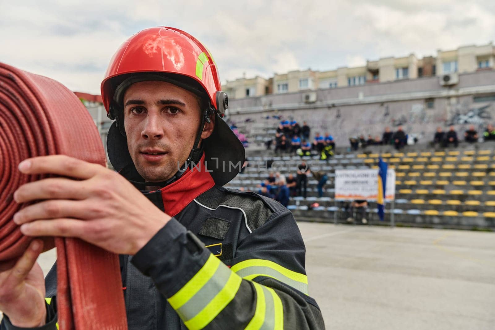 Professional Firefighter Cleaning Up Fire Hose After Extinguishing Blaze by dotshock