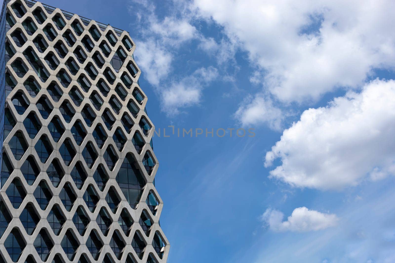 Skyscrapers, High-rise Building Shaped Like Honeycomb, Blue Sky On Background Cityscape, Tower In Urban Area. Business Development Or Financial Center Concept. Copy Space. Modern Building. Horizontal.