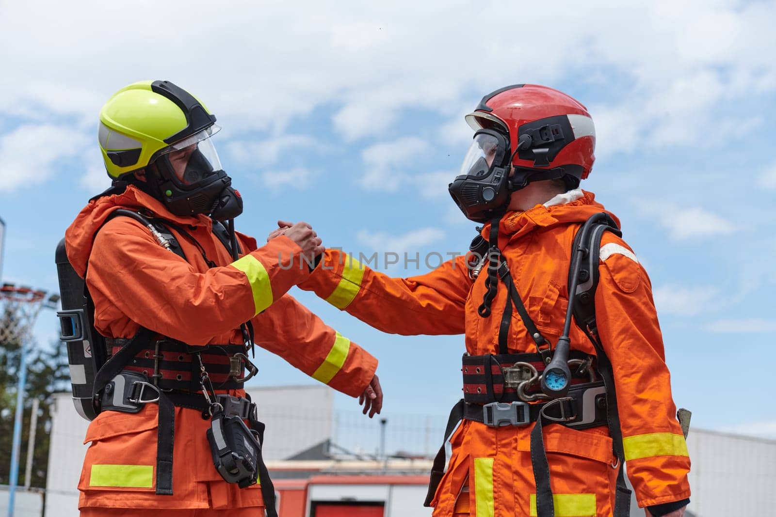 A unified team of firefighters, adorned in their uniforms, engages in a heartfelt celebration marked by triumphant salutes and cheers, embodying the joy and gratitude following the successful completion of a challenging firefighting mission.