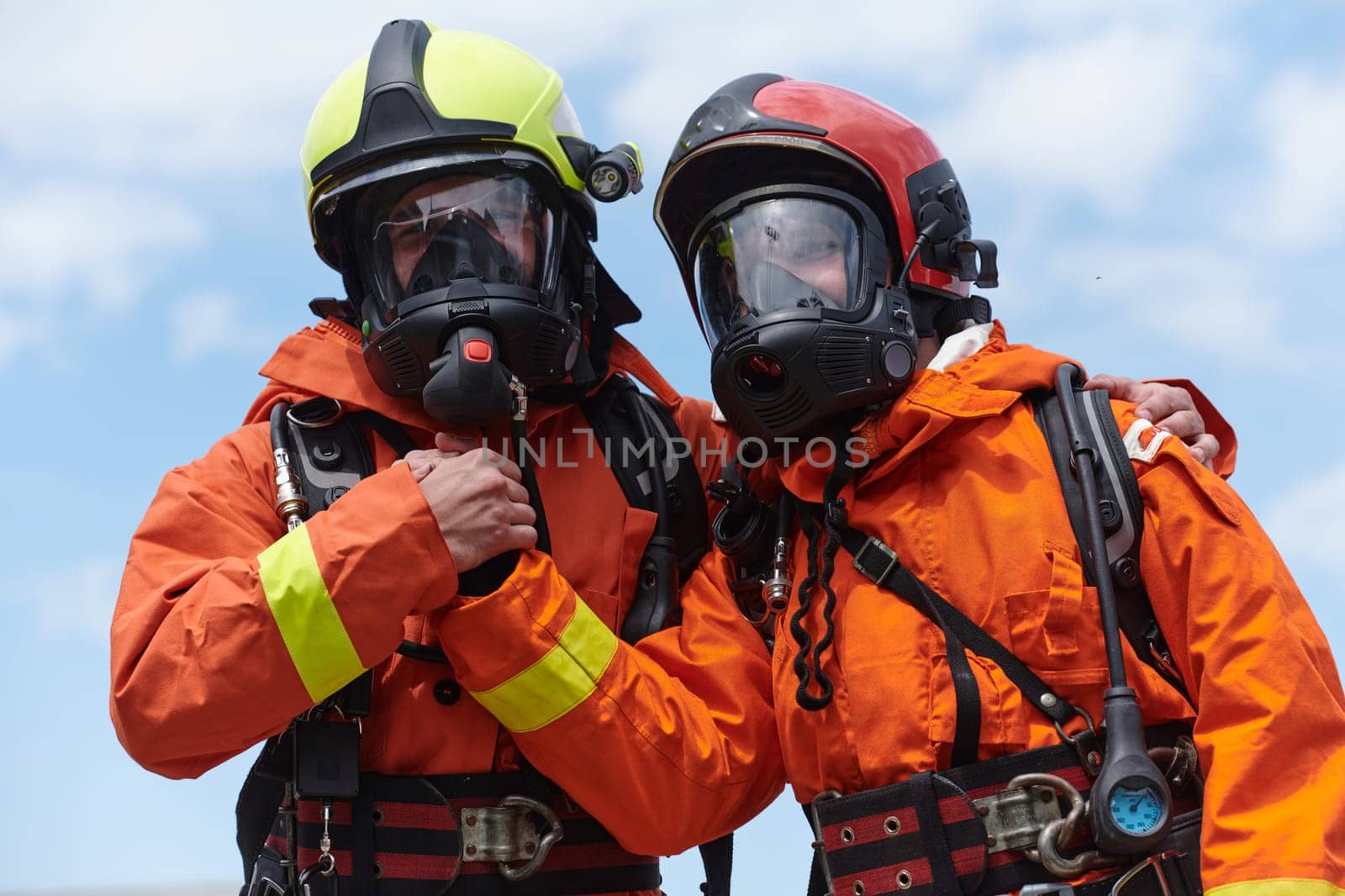 A unified team of firefighters, adorned in their uniforms, engages in a heartfelt celebration marked by triumphant salutes and cheers, embodying the joy and gratitude following the successful completion of a challenging firefighting mission.