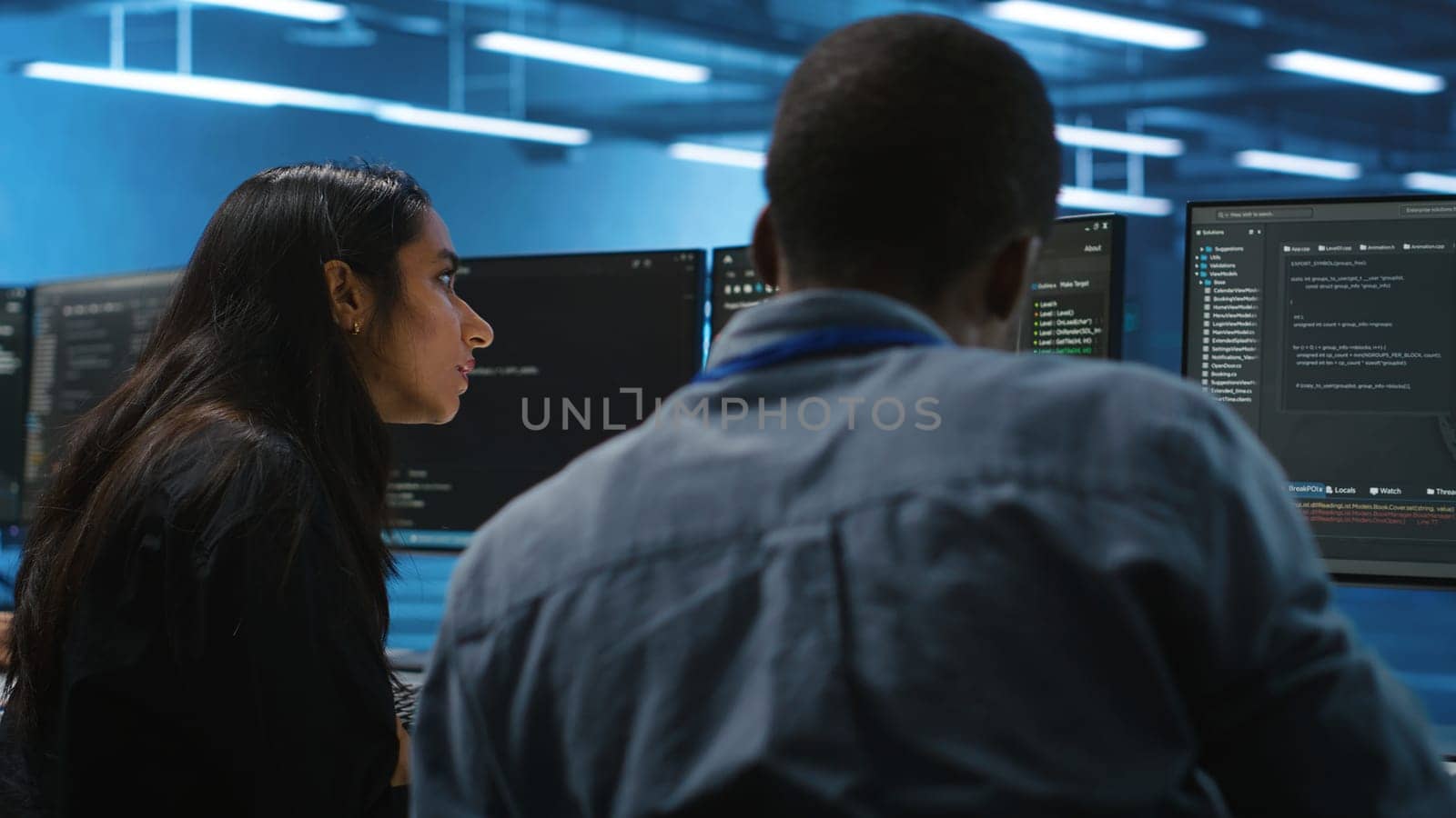 Diverse IT engineers in server room brainstorming ways to fix equipment storing datasets. Multiethnic coworkers discussing how to mend data center racks doing complex computational operations