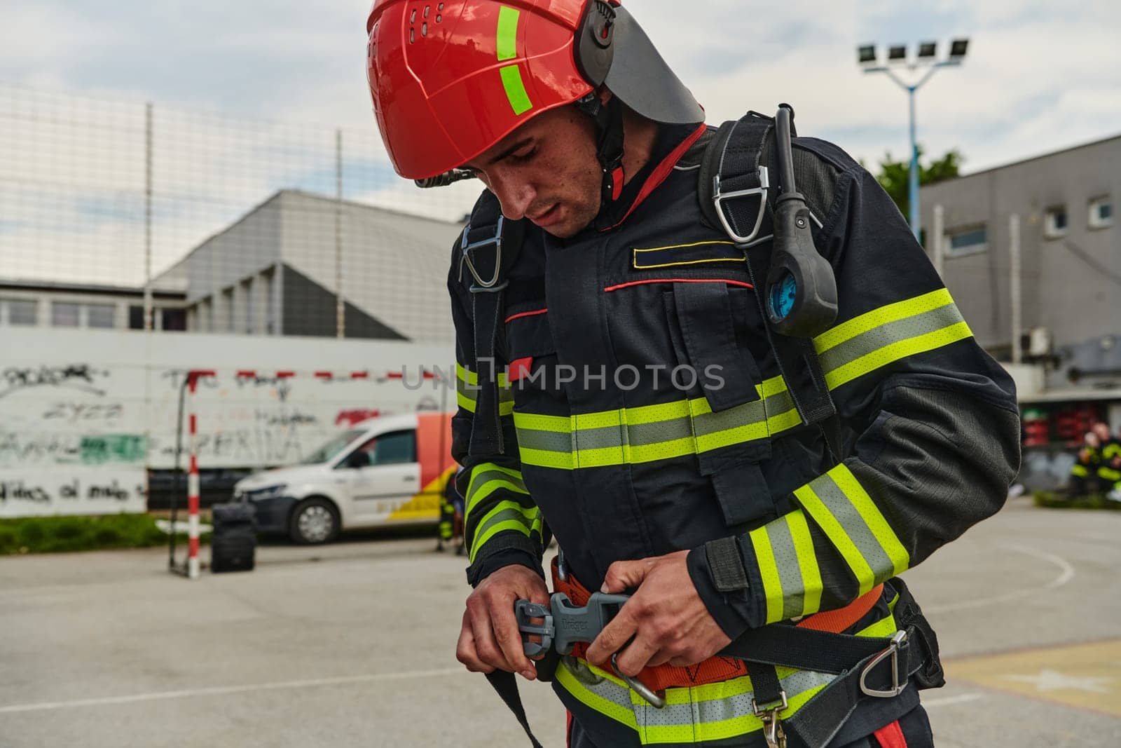 A professional firefighter dons his protective gear, preparing to respond to an emergency call.