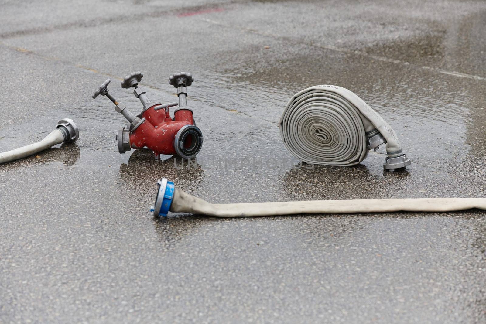 A neatly coiled fire hose lies on the ground, prepared and ready for immediate use in firefighting operations