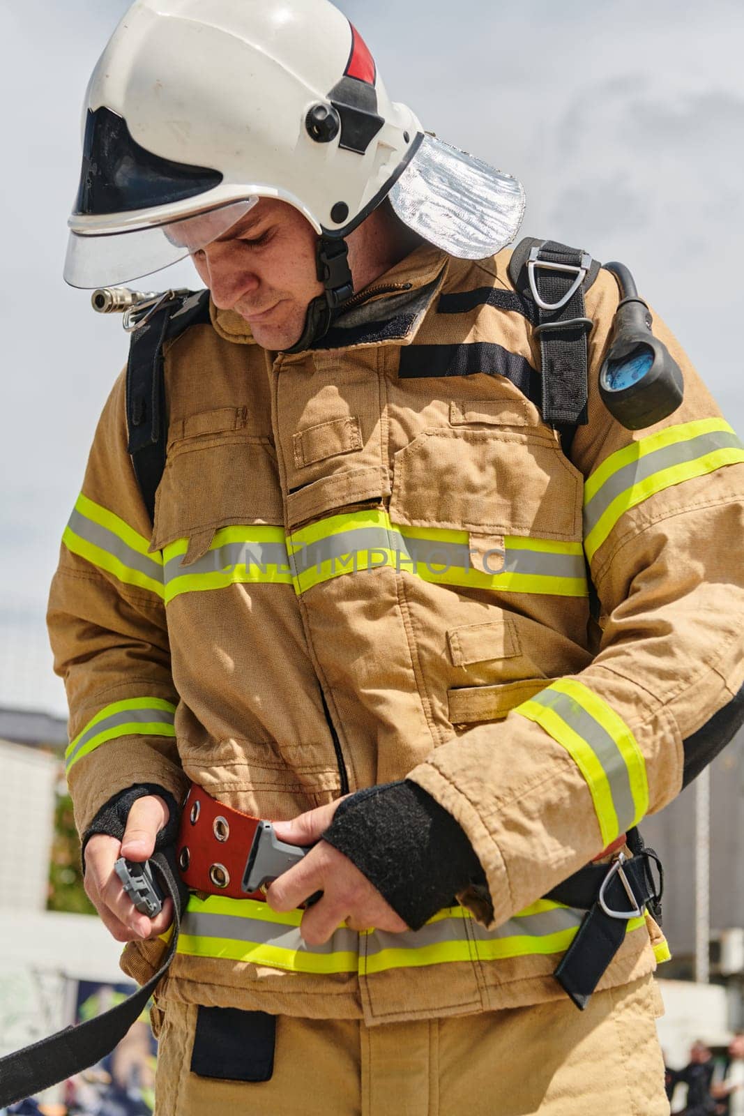 A firefighter dons the essential components of their professional gear, embodying resilience, commitment, and readiness as they gear up for a hazardous firefighting mission, a testament to their unwavering dedication to protecting and saving lives.