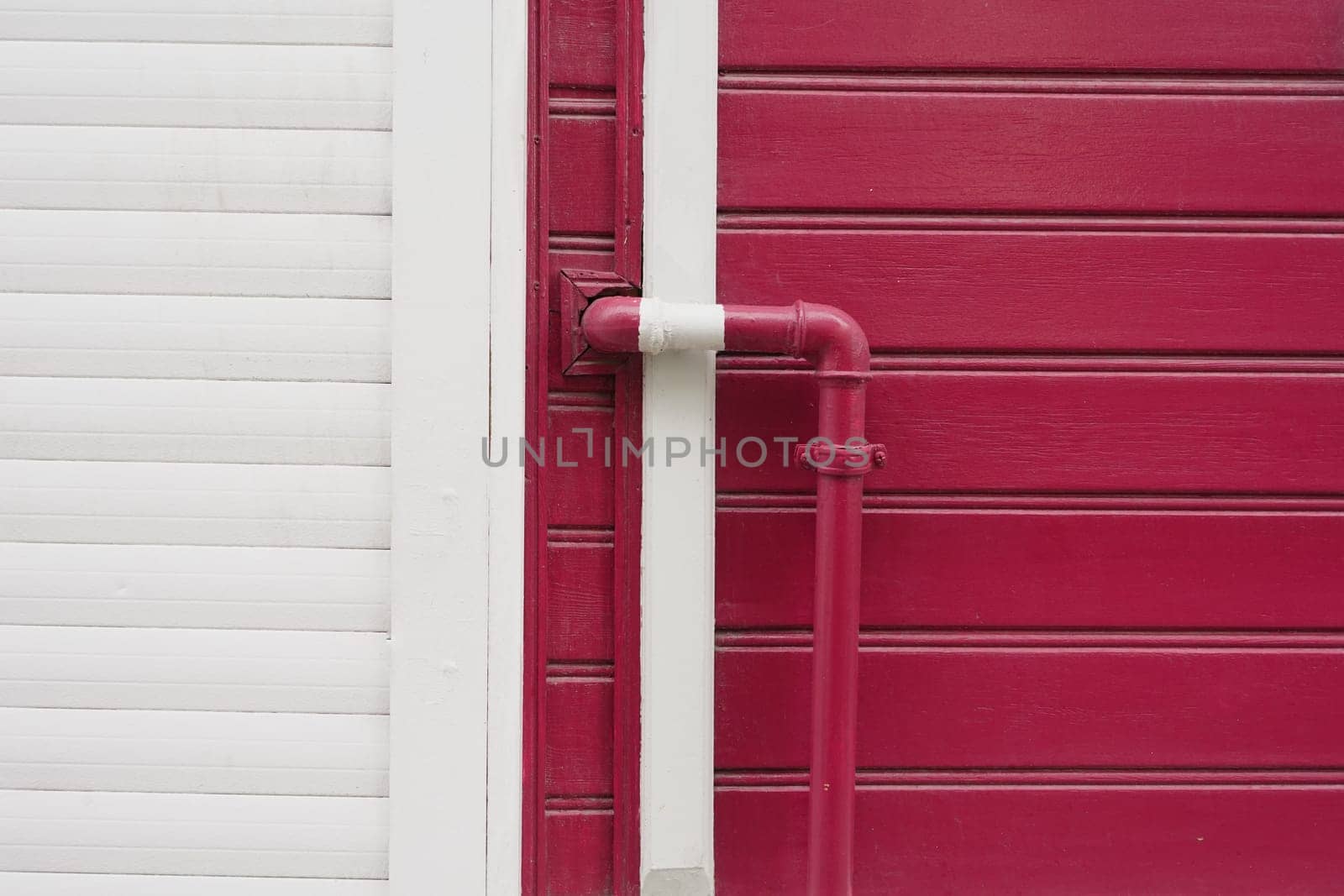 red wall with pipe, displaying modern urban design with vibrant colors,