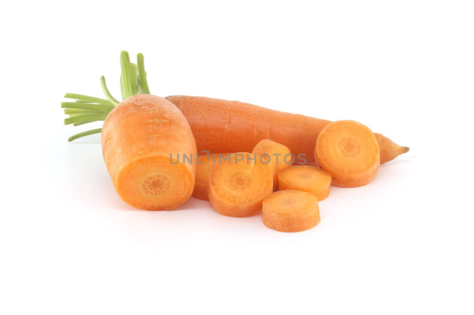 Whole carrot alongside its sliced pieces, each exhibiting a vibrant orange hue, set against a white background