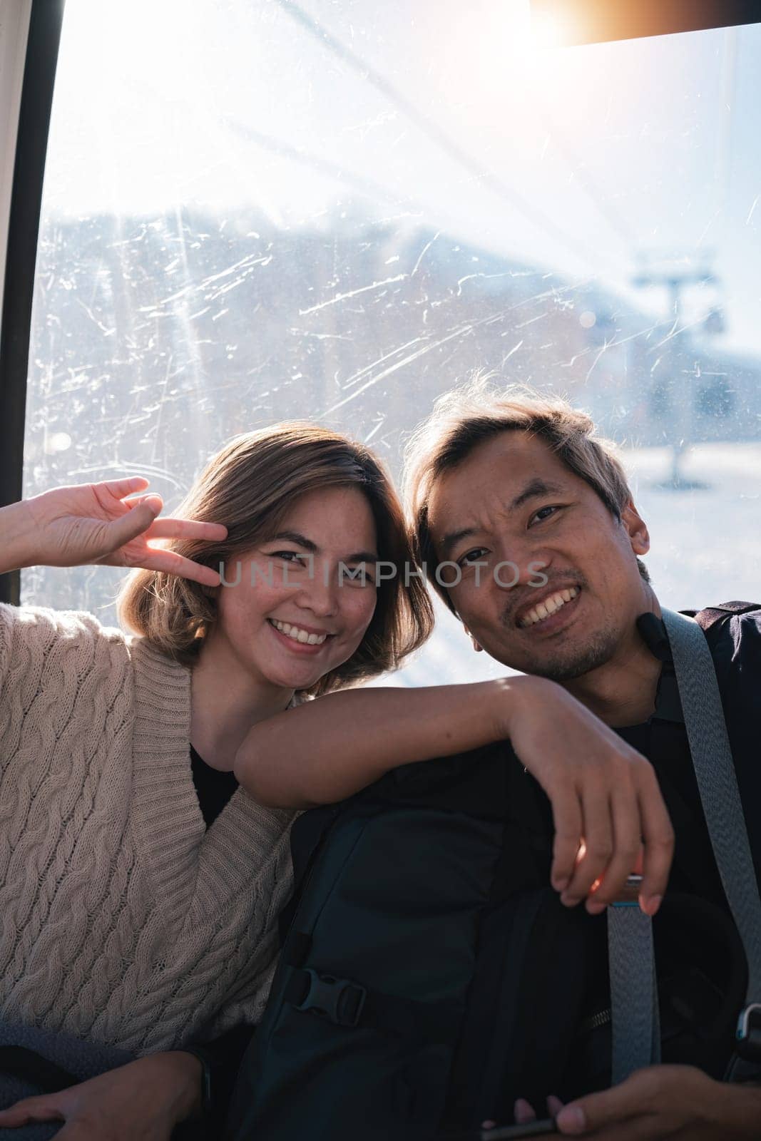 Smiling couple posing inside cable car. Concept of joy and travel.