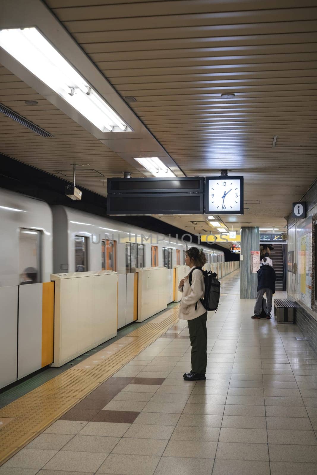 Woman waiting for subway train in station. Concept of travel and urban commuting.