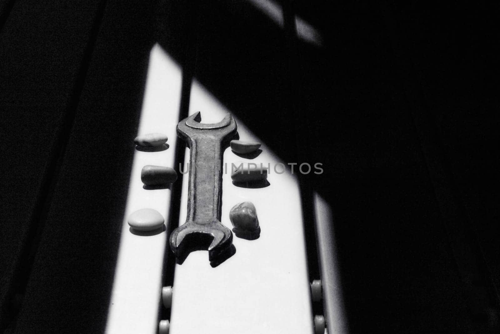 Old metal wrench on a workbench illuminated by the sun by jovani68