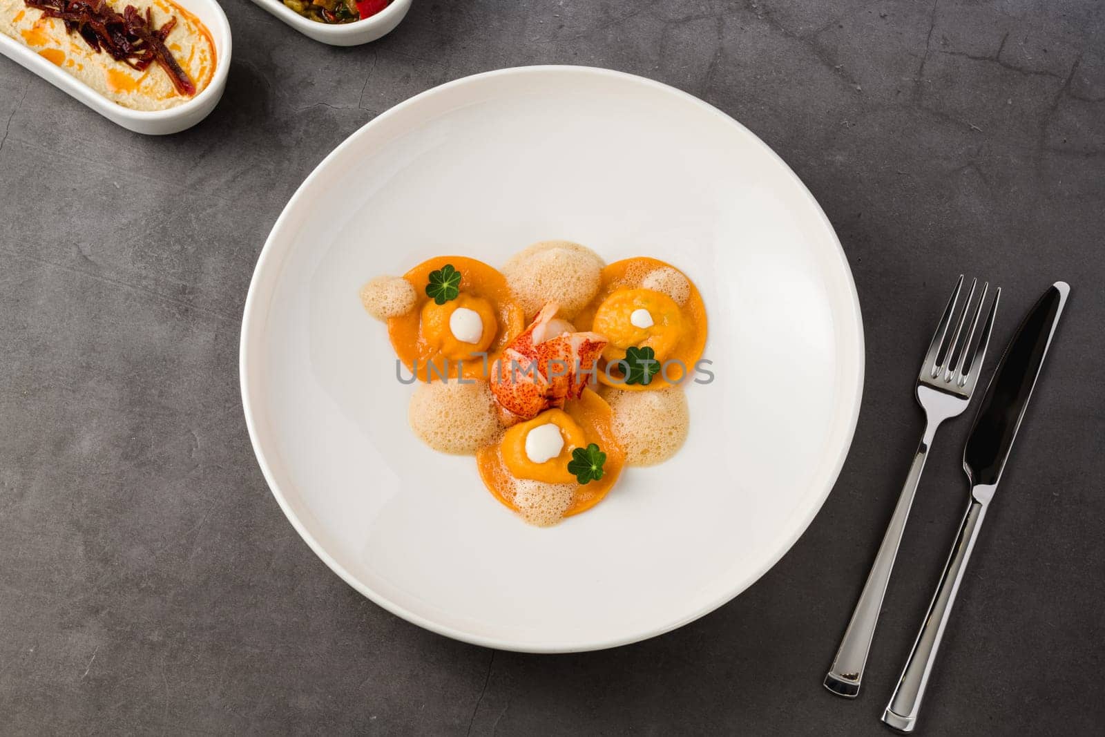 Ravioli with grilled shrimp on a white porcelain plate by Sonat