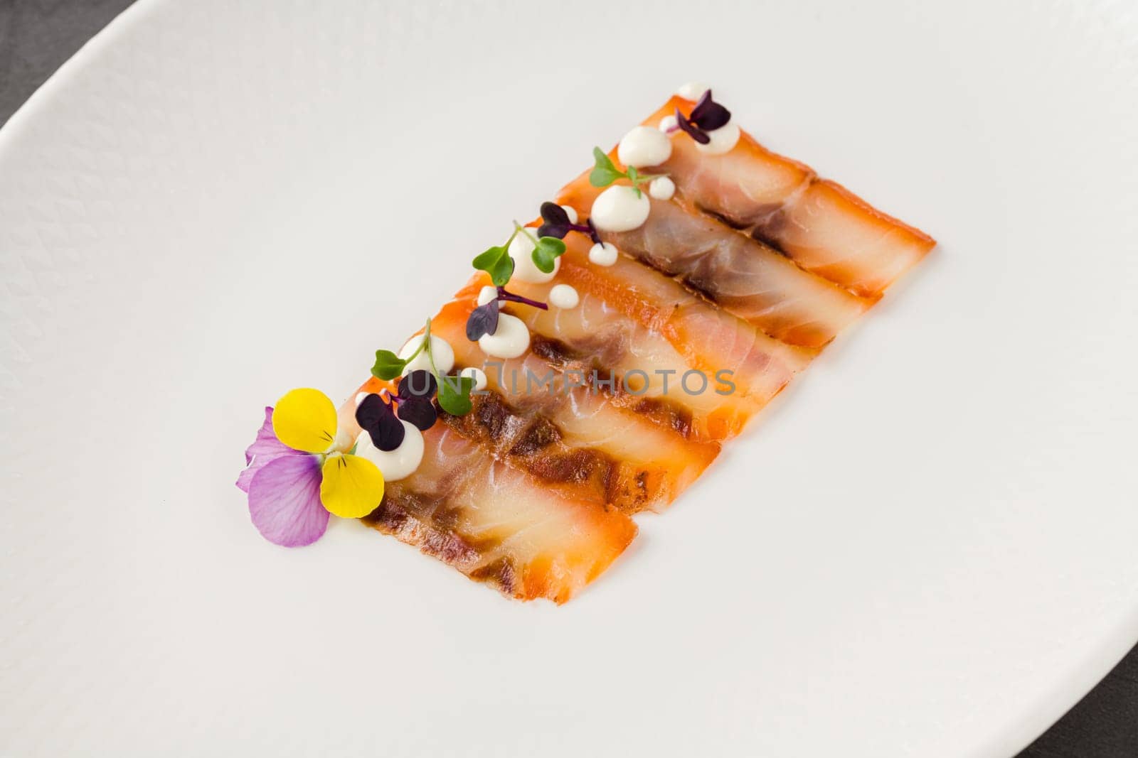 Smoked fish pastrami or bacon on a white porcelain plate by Sonat