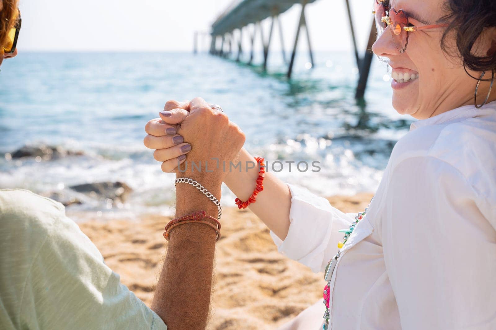 Couple friends high fiving each other on the beach. Holiday Friendship Concept