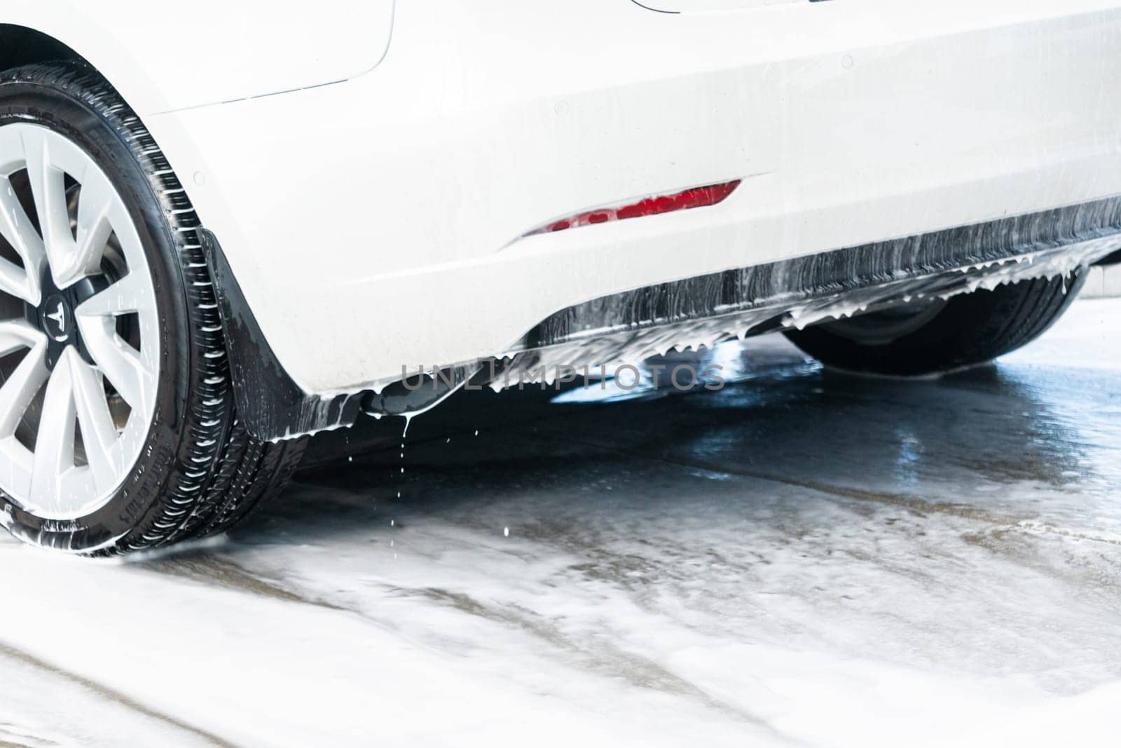 Denver, Colorado, USA-September 1, 2023-Efficiently cleaning an electric car in the comfort of a suburban driveway, combining eco-consciousness with practicality.