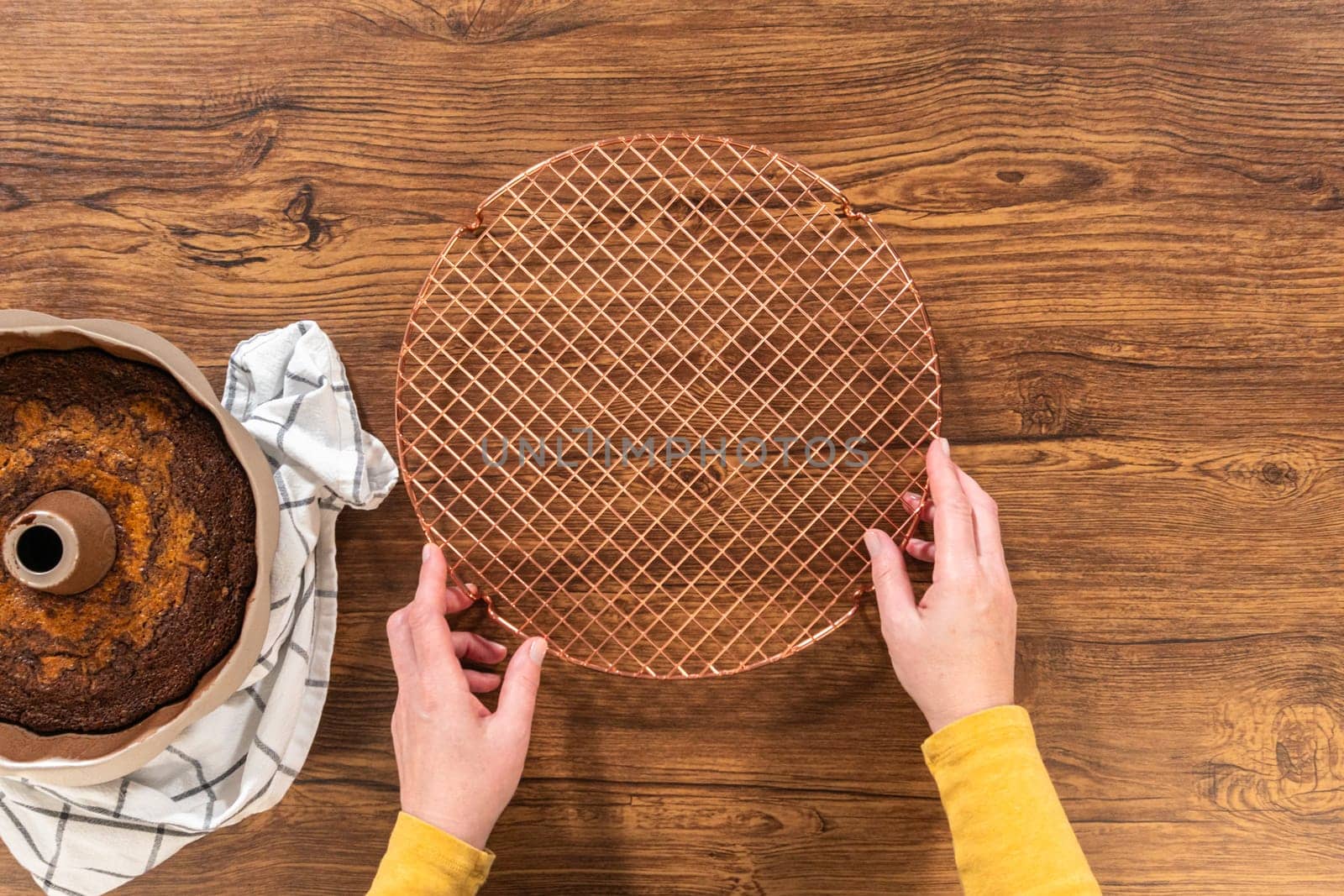 Flat lay. The gingerbread bundt cake cools gracefully on a wire rack, awaiting its sweet caramel frosting.