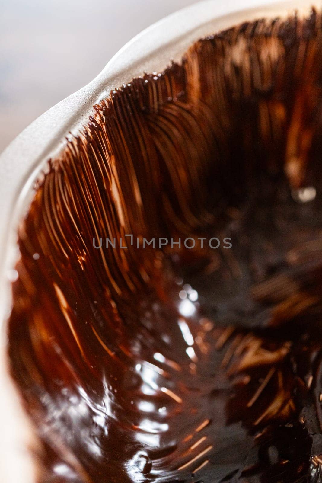 Carefully greasing a bundt cake pan in preparation for baking a delicious gingerbread bundt cake with caramel frosting.