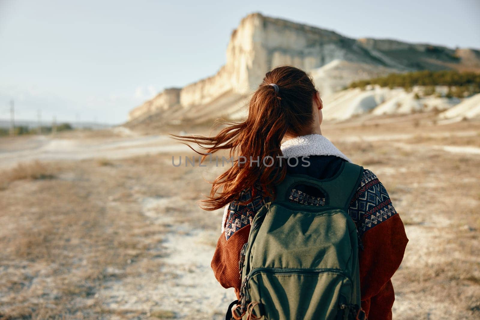 Adventure awaits woman with backpack in front of majestic mountain with desert landscape in background