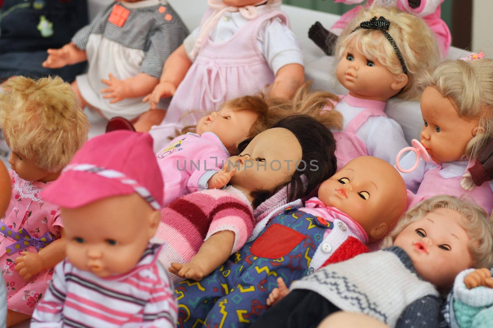 Many vintage dolls in a hat at the flea market