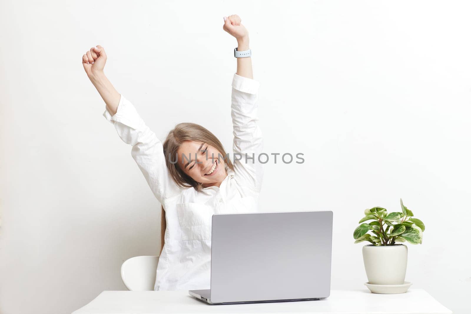 happy girl with laptop rejoices at successful work while working in the office, success at work by SergiiKolesnikov