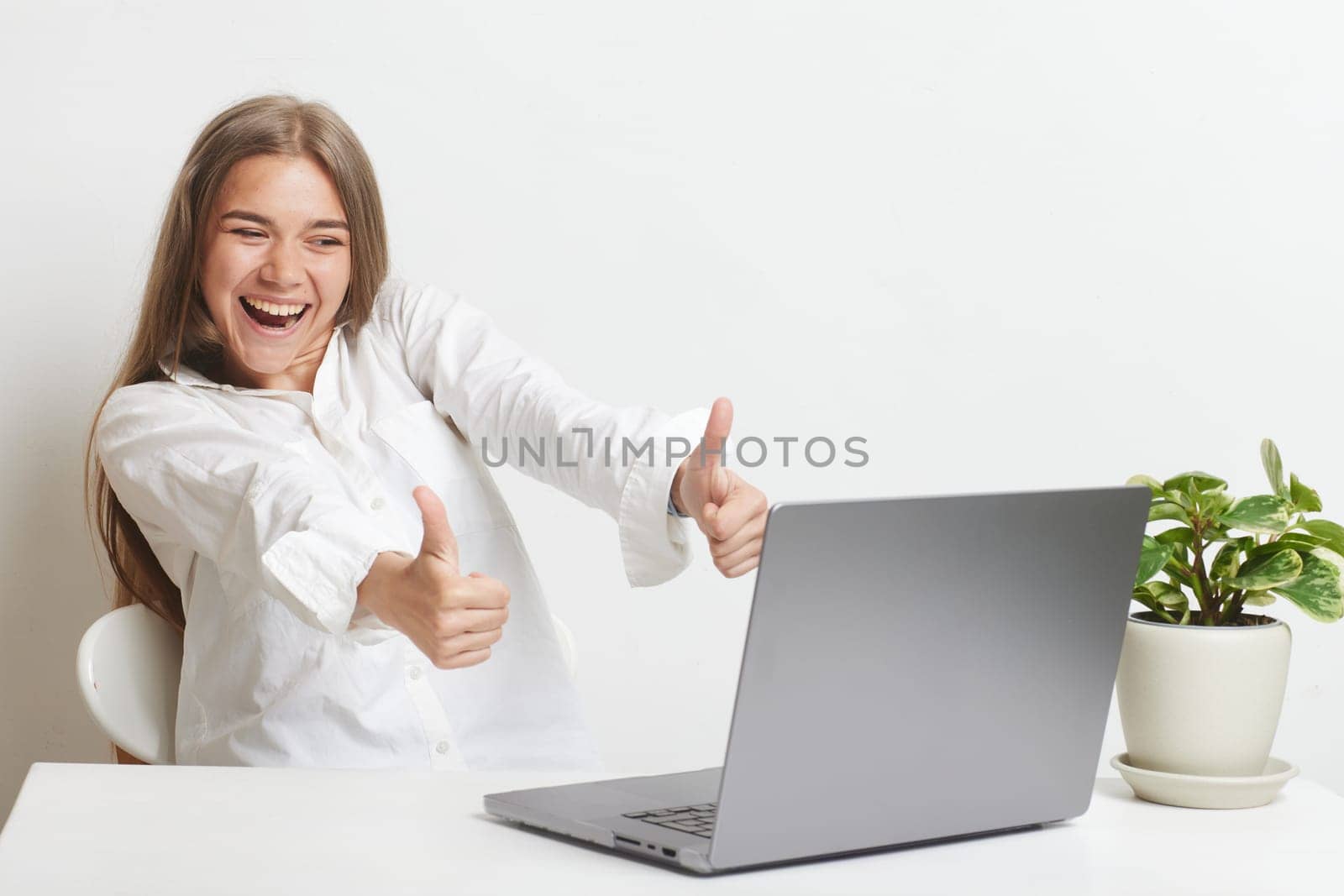 happy girl with a laptop rejoices at a successful job working in the office, successful business, online winning, successful decision