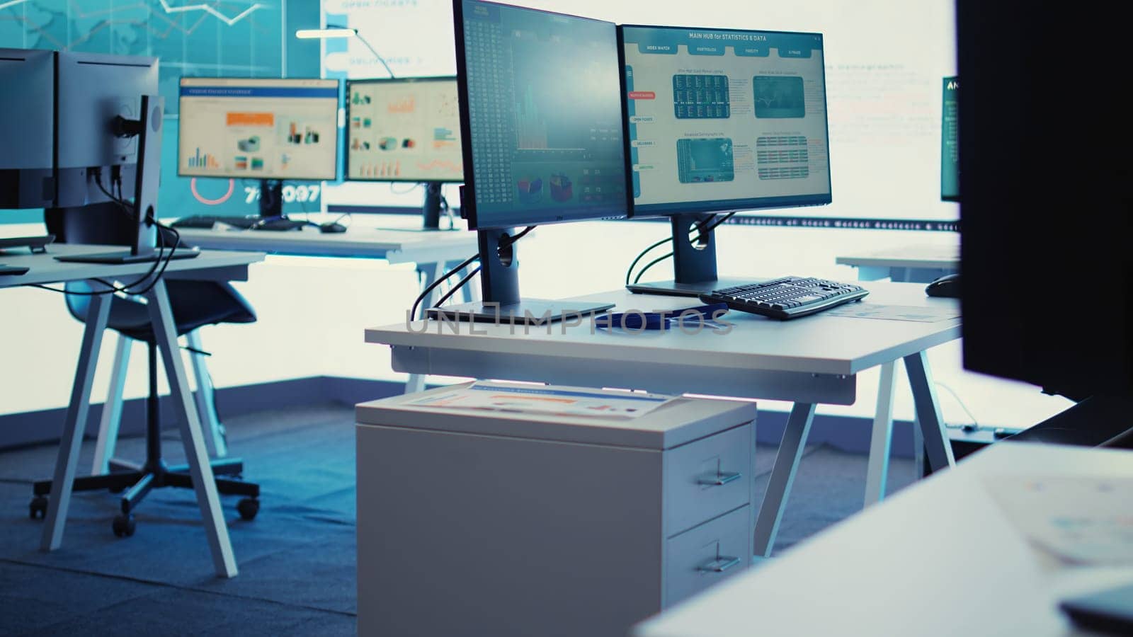 Empty telecommunications control room with workstations, coworking space equipped with a big screen and modern devices used in organizational daily tasks and projects. Camera B.