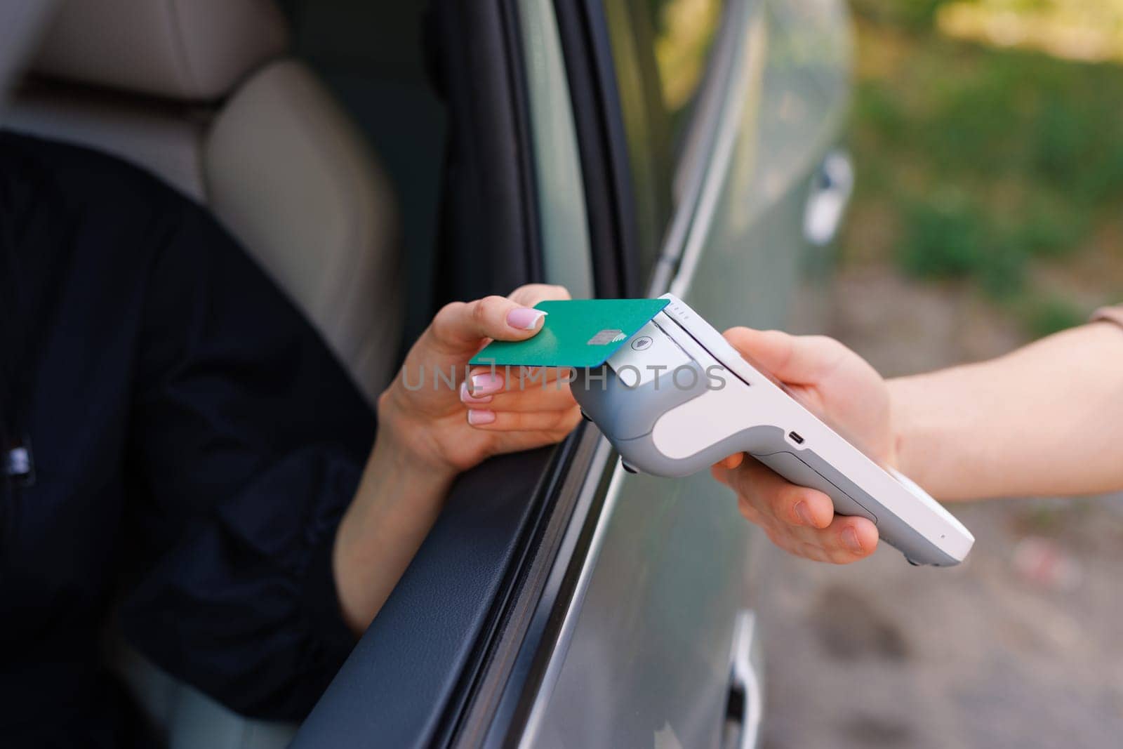 the driver makes contactless NFC payment with a credit card, payment by card for car services, charging an electric car, delivery of online purchases