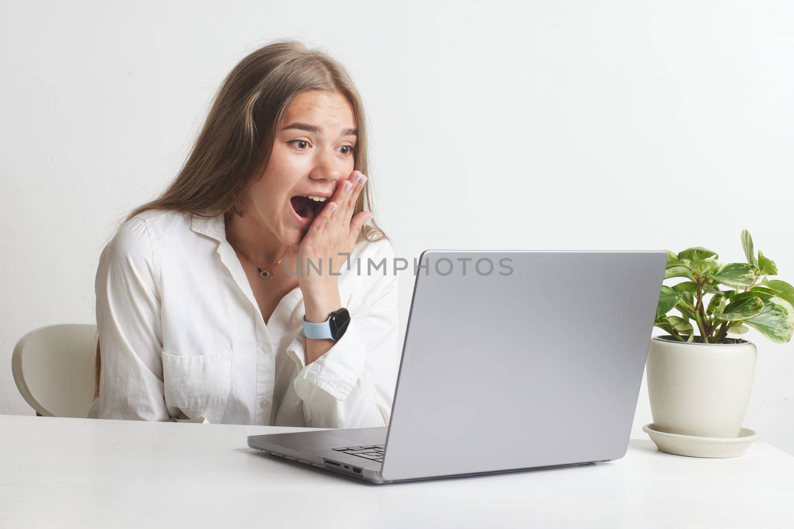 happy girl with a laptop rejoices at a successful job working in the office, successful business, online winning, successful decision