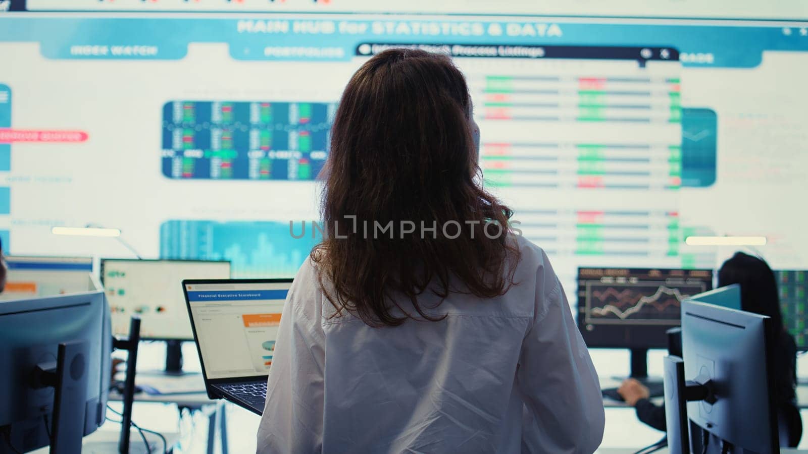 Project leader conducting a market research with a big screen in company headquarters office, ensuring enterprise progress. Financial manager studying the current organizational situation. Camera B.