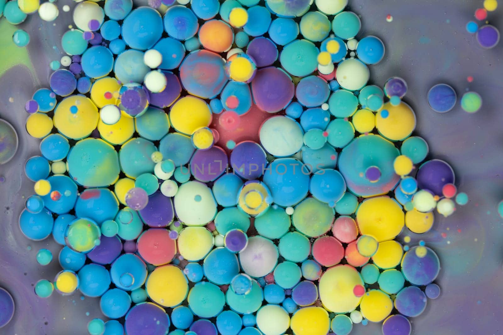 A close-up photograph showcasing a mesmerizing array of colorful bubbles suspended in a liquid medium, creating a stunning abstract composition. The bubbles exhibit a vibrant spectrum of hues.