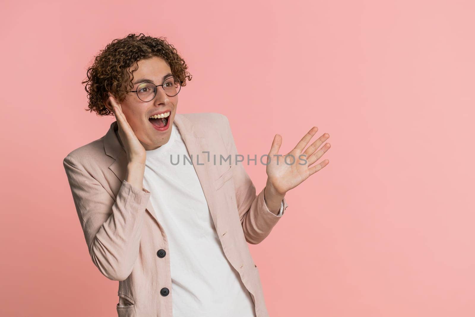 Oh my God, Wow. Excited amazed winner man raising hands in surprise looking at camera with big eyes shocked by sudden victory celebrating success achievement good news. Guy on pink background