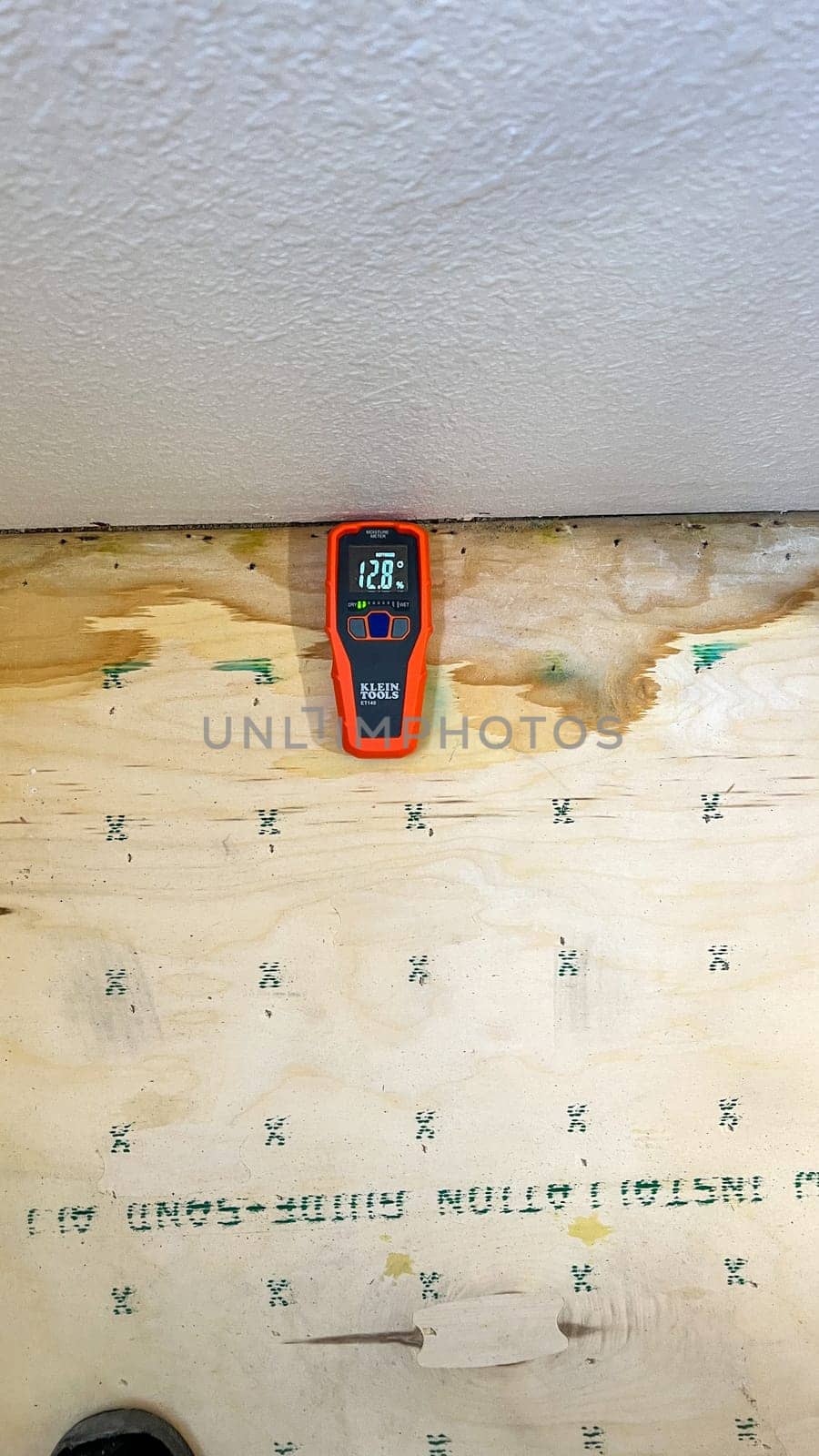 Denver, Colorado, USA-May 19, 2024-A Klein Tools moisture meter is shown measuring the moisture content in a piece of plywood, indicating 30.1 percent. The scene highlights the importance of moisture detection in construction and woodworking.