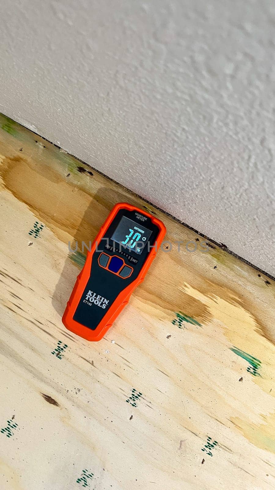 Denver, Colorado, USA-May 19, 2024-A Klein Tools moisture meter is shown measuring the moisture content in a piece of plywood, indicating 30.1 percent. The scene highlights the importance of moisture detection in construction and woodworking.