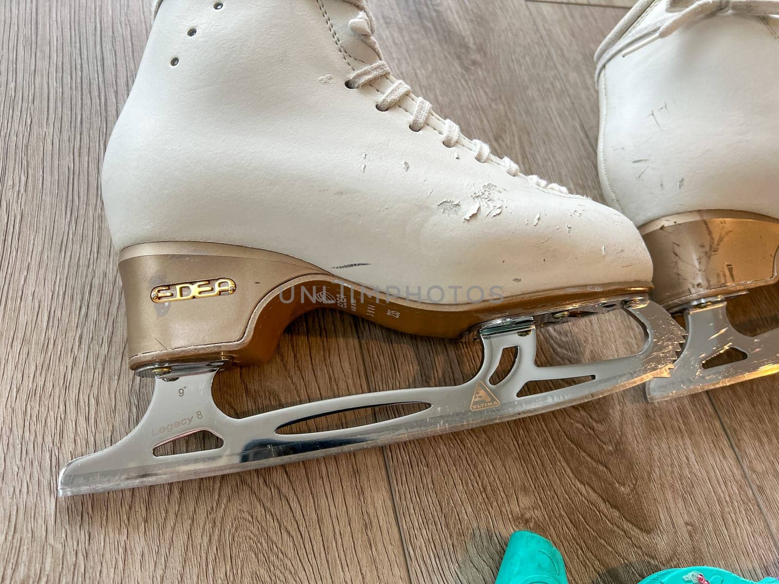 Pair of White Ice Skates on Wooden Floor by arinahabich
