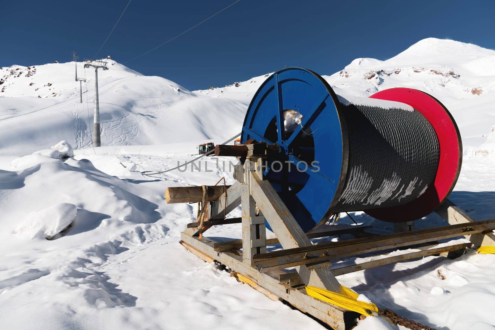 Power cable on reels. Thick electrical wire. Wire spools for outdoor use. Electrical products at a ski resort en street in the snow.