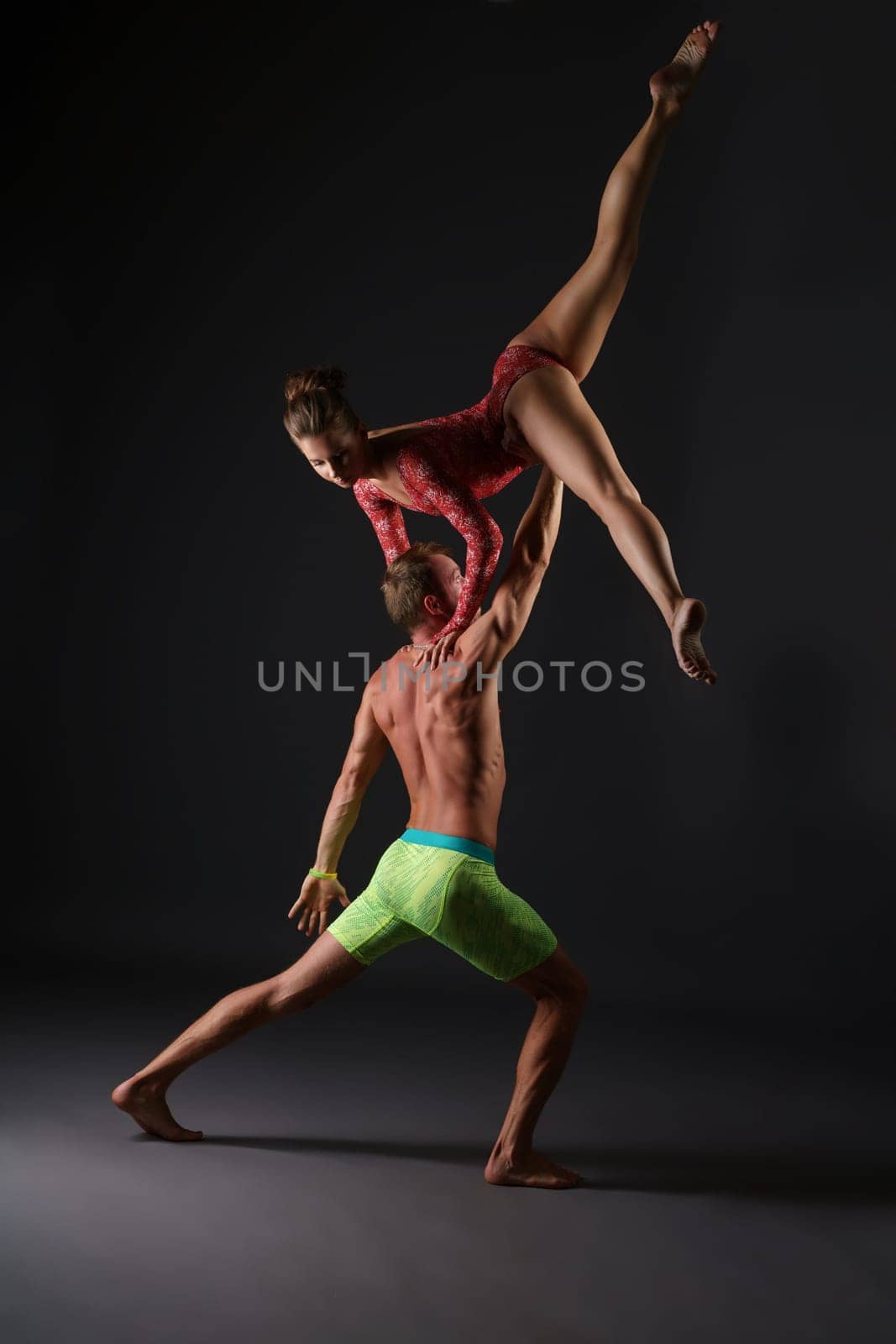 Acrobatics. Duet of gymnasts perform trick in studio