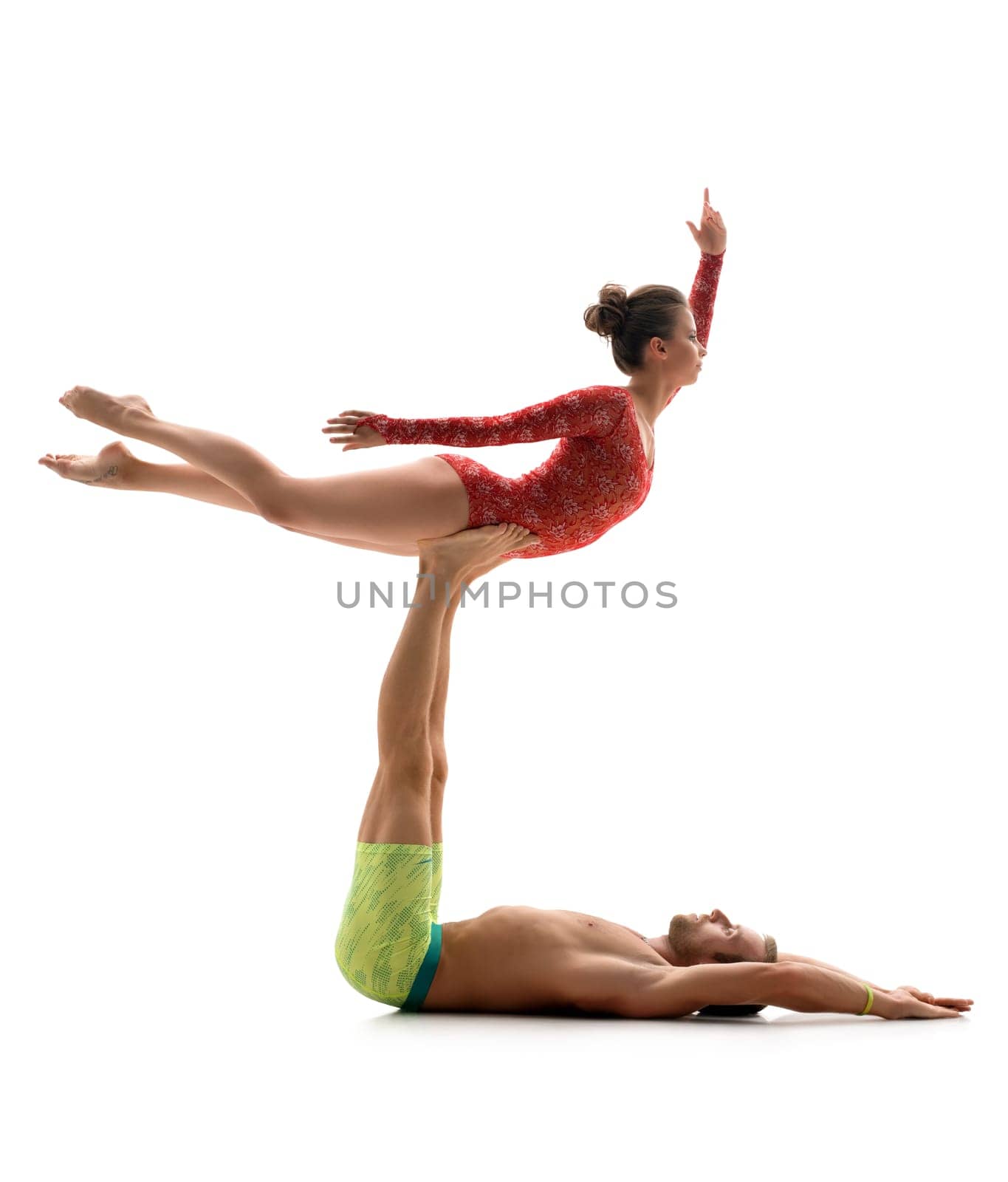 Couple of strong athletic acrobats performing difficult trick together, isolated on white, studio shot