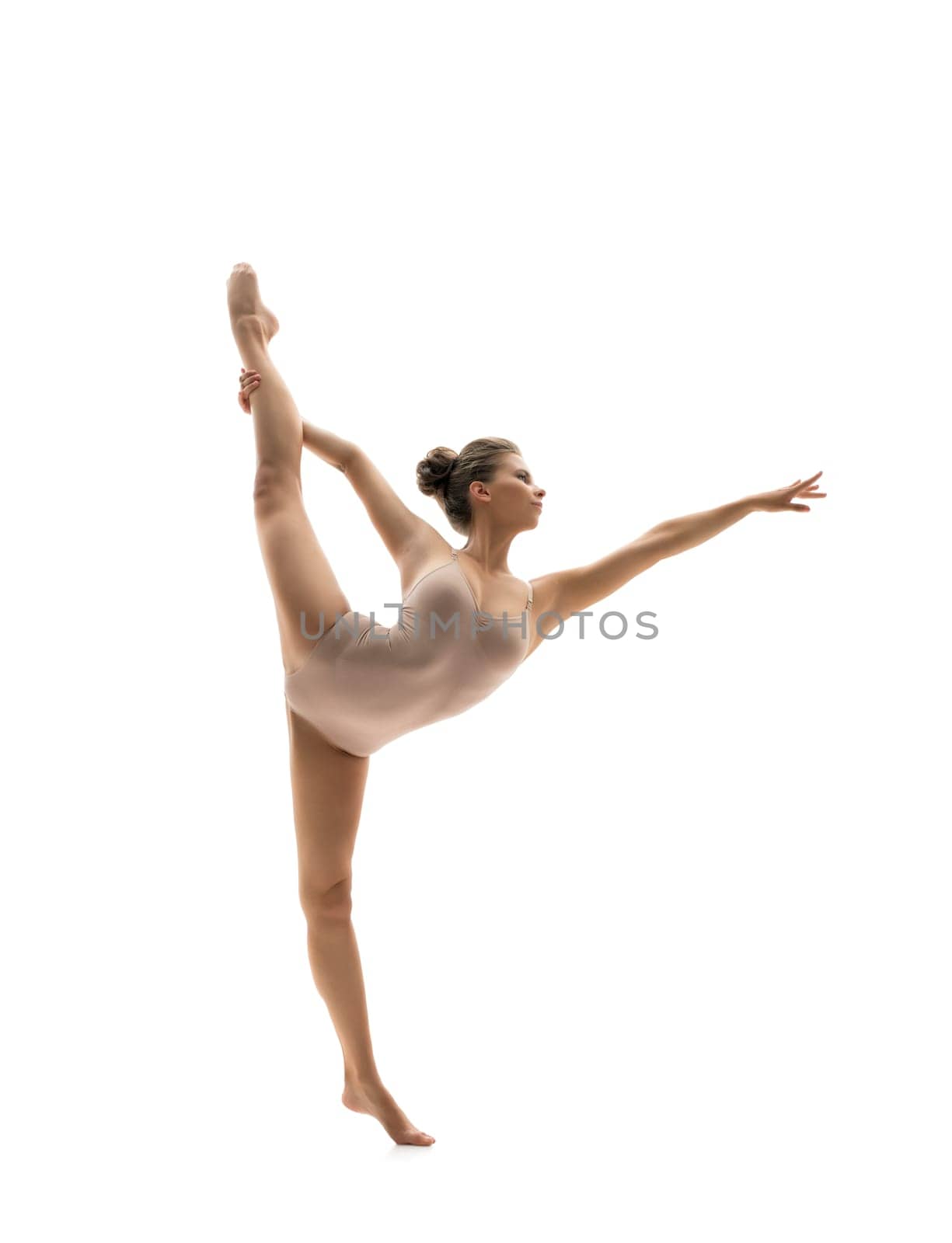 Graceful dancer performs vertical gymnastic split. Isolated on white