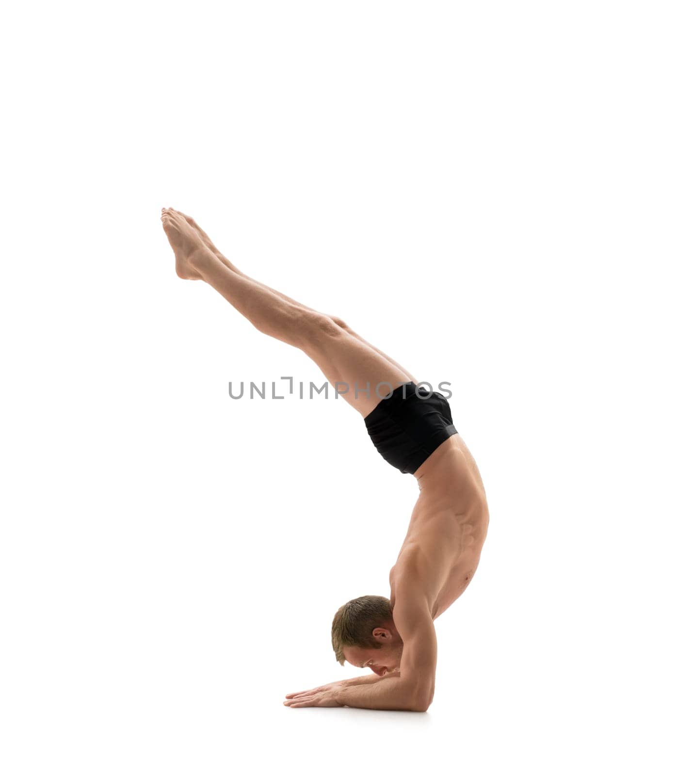 Sport. Athlete doing handstand, isolated on white background