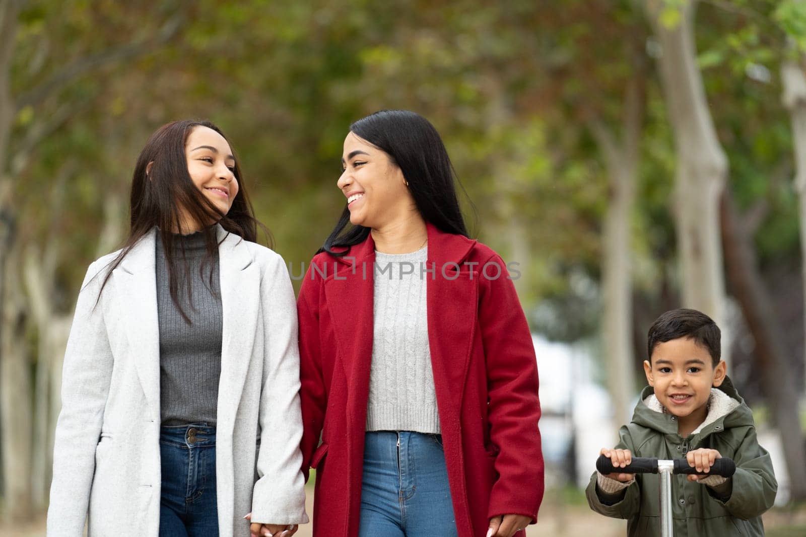 Front view of lesbian latin family spending time together in a park .LGBT family.