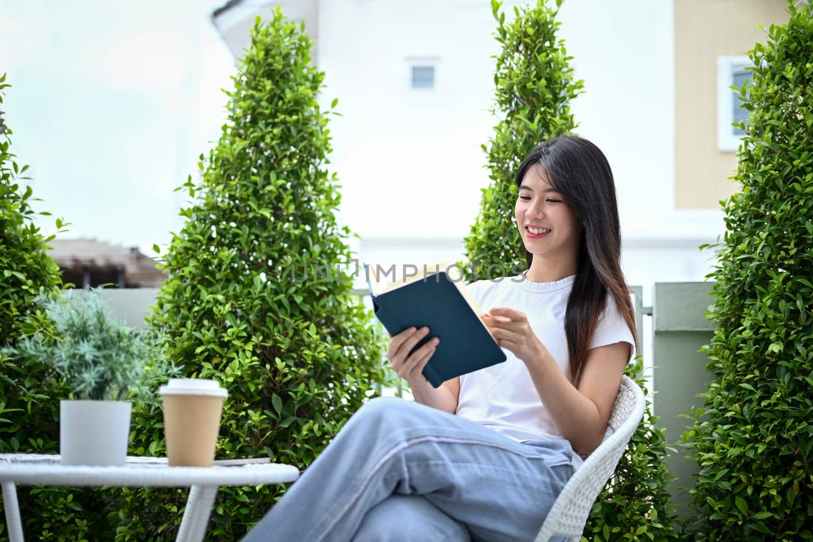 Pretty young woman enjoy relaxing in the garden and reading book.