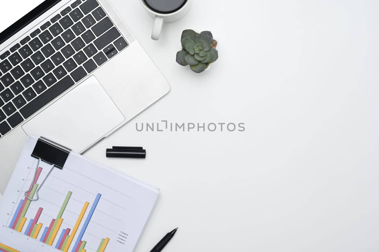 Office desk with laptop, financial reports and coffee cup. Top view with copy space by prathanchorruangsak