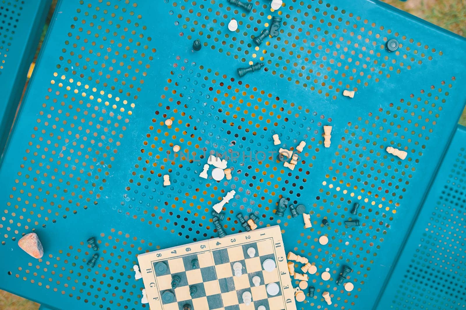 Scattered chess summer day on the green table in the Park