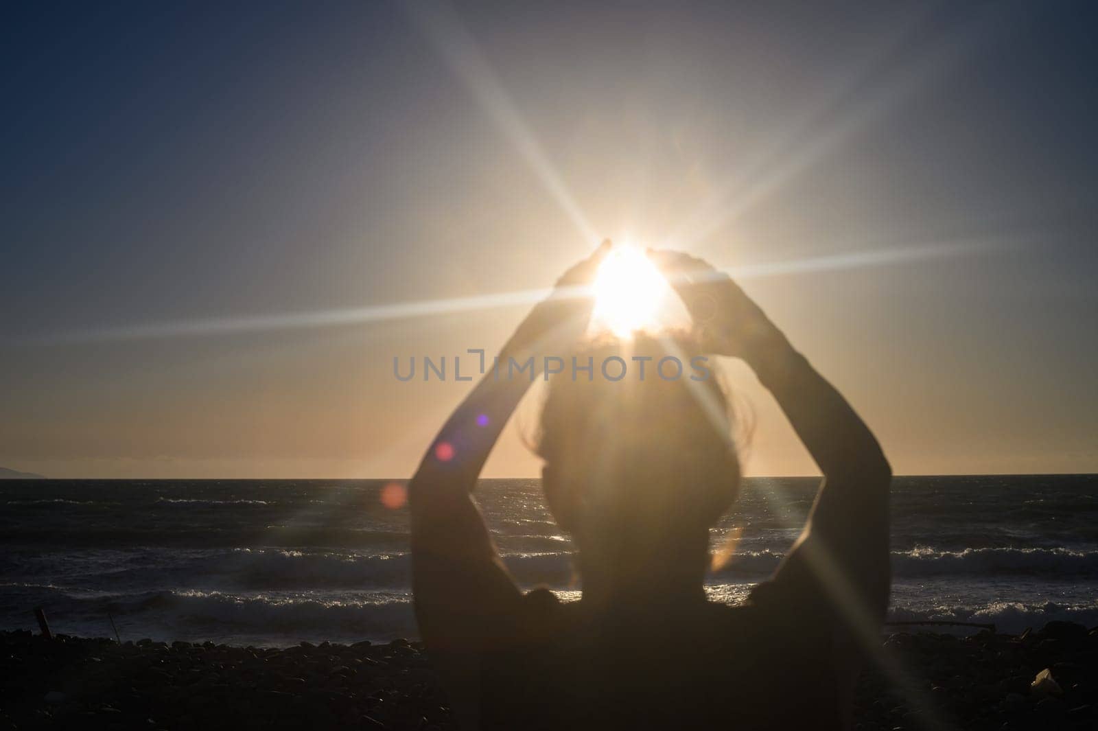 Silhouette of a woman holding the sun in the palm of her hand. by Mixa74